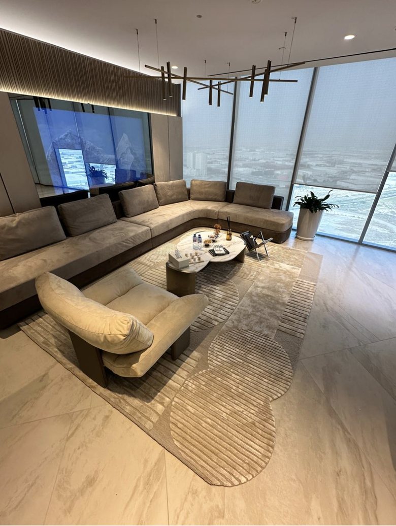 A hand-knotted rug laid in a high-rise living space, its ribbed pile catching low afternoon light.